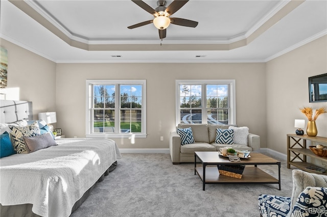 bedroom with carpet flooring, ceiling fan, a tray ceiling, and ornamental molding