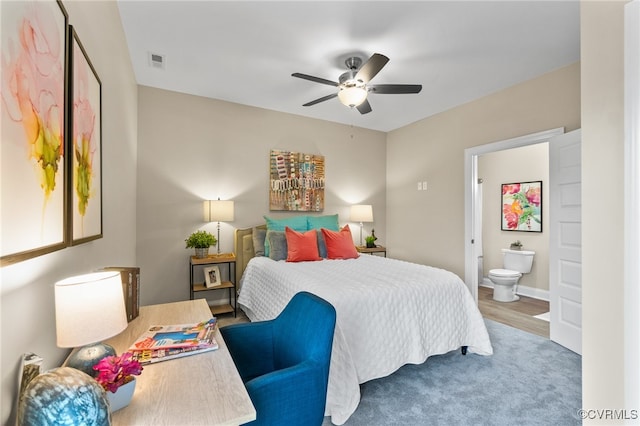 bedroom with ensuite bathroom, hardwood / wood-style floors, and ceiling fan