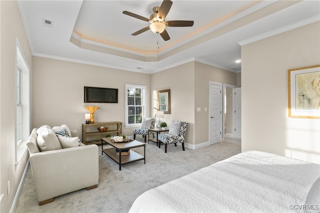 carpeted bedroom featuring a tray ceiling, ceiling fan, and ornamental molding