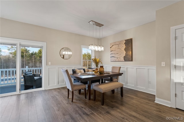 dining space featuring plenty of natural light, dark wood-type flooring, and a notable chandelier