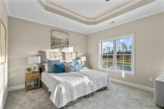 carpeted bedroom featuring a tray ceiling and ornamental molding