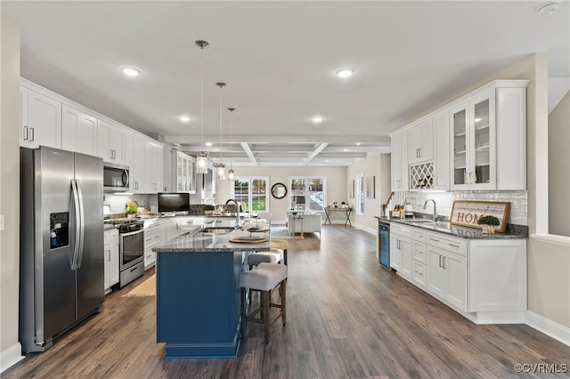 kitchen with pendant lighting, stainless steel appliances, white cabinetry, and dark hardwood / wood-style floors