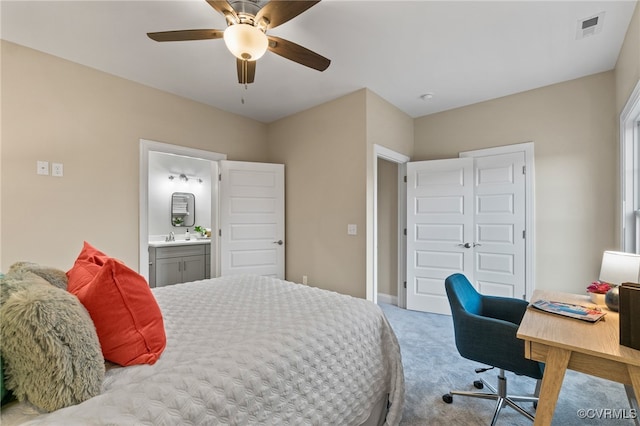 bedroom with connected bathroom, ceiling fan, sink, and light carpet