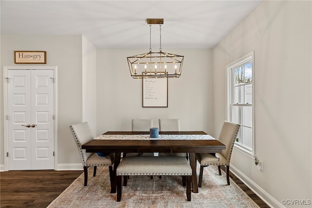 dining area with dark wood-type flooring and a chandelier