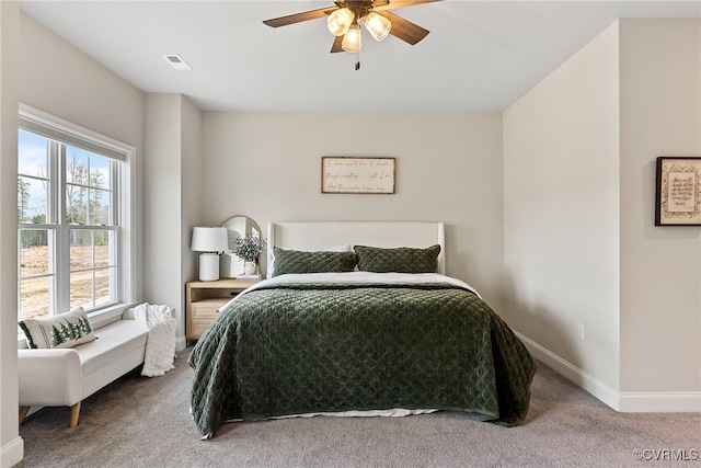 bedroom with multiple windows, ceiling fan, and carpet floors