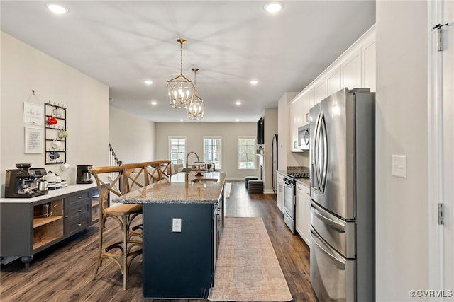 6412 Sanford Springs Cv, Midlothian, VA 23112 - kitchen featuring appliances with stainless steel finishes, a breakfast bar, dark wood-type flooring, white cabinetry, and recessed lighting