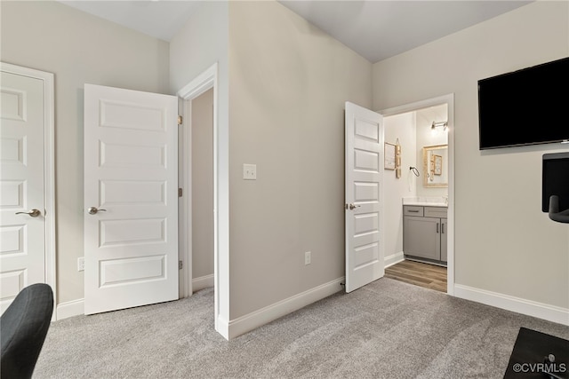 unfurnished bedroom featuring connected bathroom and light colored carpet