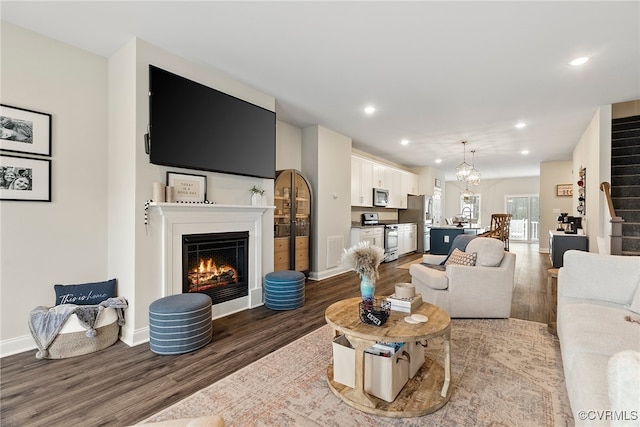 living room with hardwood / wood-style flooring and a notable chandelier