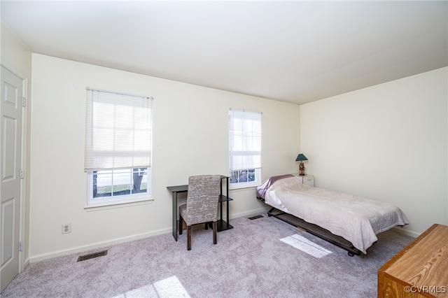 carpeted bedroom featuring multiple windows