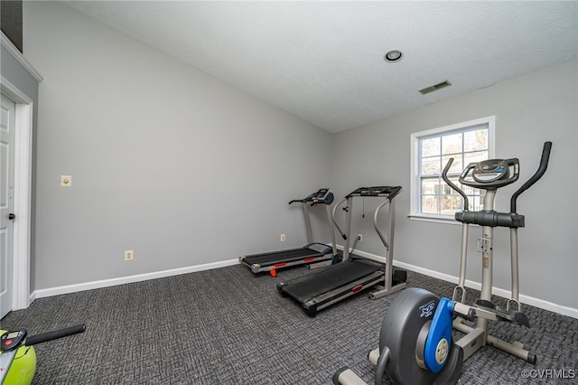 workout area featuring carpet and a textured ceiling