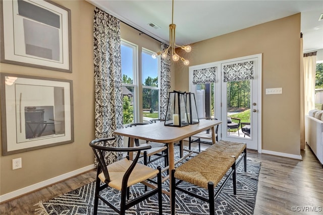 dining room featuring a healthy amount of sunlight, a chandelier, and wood-type flooring