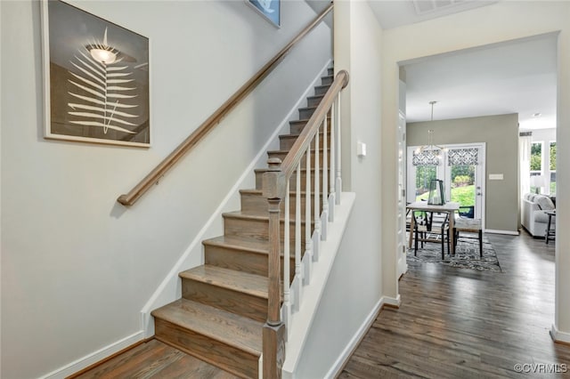 stairs featuring an inviting chandelier and hardwood / wood-style floors