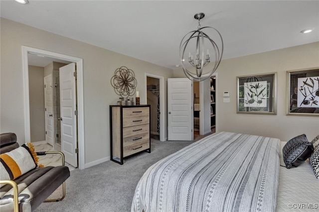 carpeted bedroom with a spacious closet and a chandelier