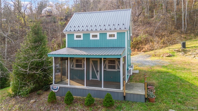 view of outdoor structure featuring a sunroom and a yard