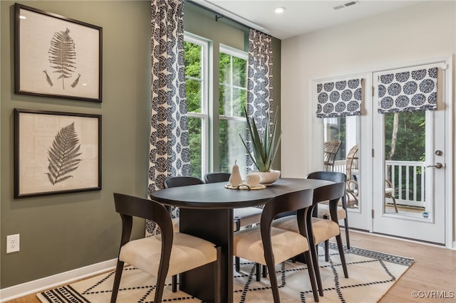 dining room featuring light wood-style flooring, visible vents, and baseboards