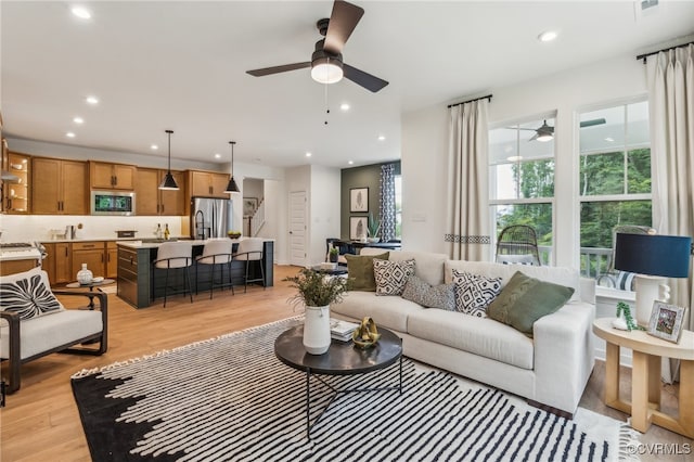 living room featuring recessed lighting, light wood-type flooring, and a ceiling fan