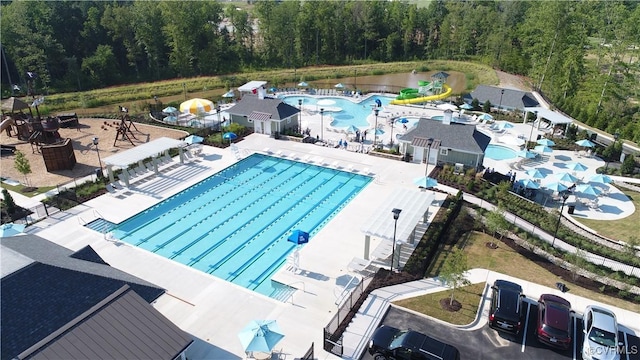 community pool with a patio and a forest view