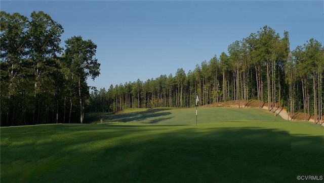 view of property's community with view of golf course and a lawn