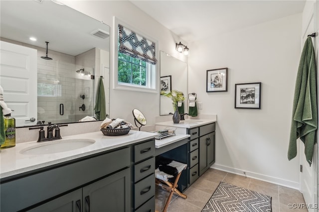 bathroom with tile patterned flooring, visible vents, a shower stall, baseboards, and vanity