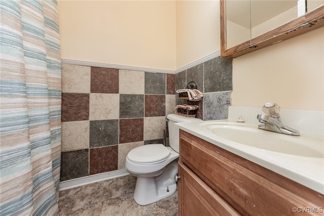 bathroom featuring vanity, toilet, and tile walls