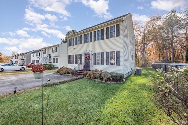 view of front of house with a front yard and central air condition unit