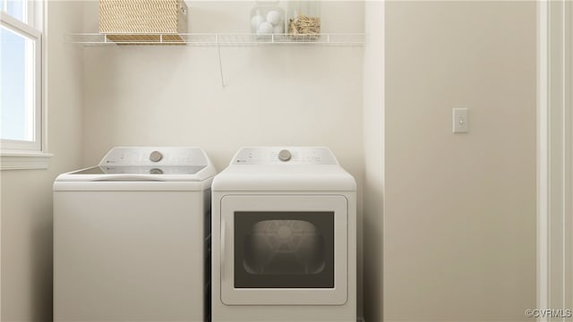 clothes washing area with a wealth of natural light and washing machine and clothes dryer