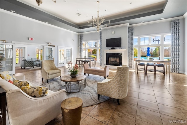 living room featuring a tray ceiling, a premium fireplace, and plenty of natural light