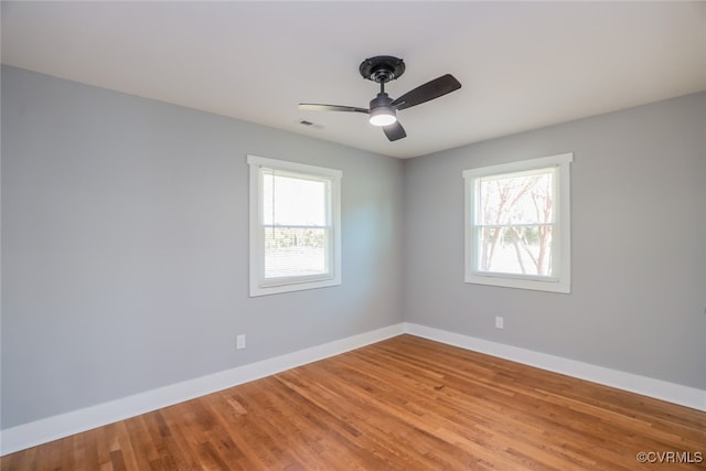 spare room featuring hardwood / wood-style floors, plenty of natural light, and ceiling fan