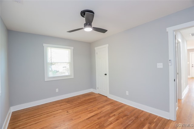 empty room with ceiling fan and light hardwood / wood-style flooring