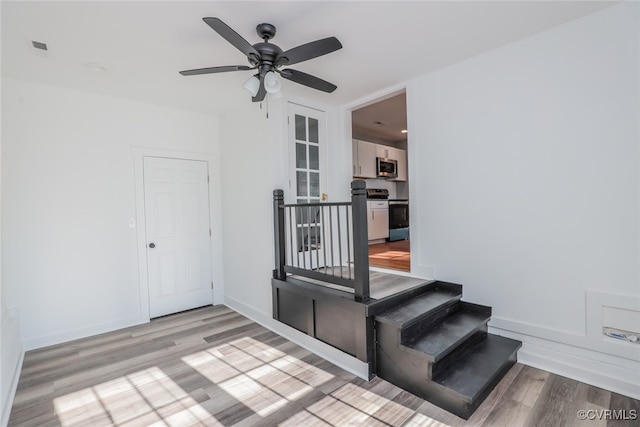 stairs with ceiling fan and hardwood / wood-style floors