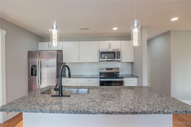 kitchen featuring white cabinets, appliances with stainless steel finishes, backsplash, and sink