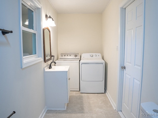 clothes washing area with separate washer and dryer, sink, and light tile patterned floors