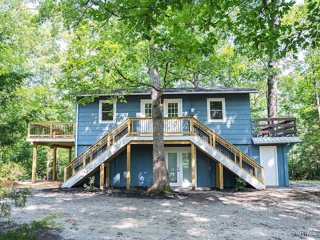 rear view of property with french doors and a wooden deck