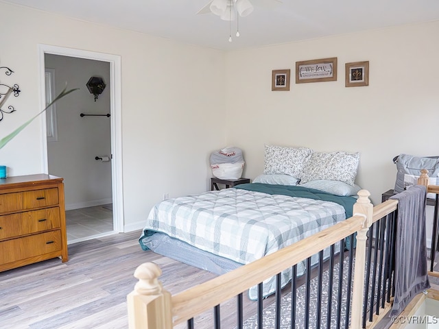 bedroom with connected bathroom, ceiling fan, and light hardwood / wood-style flooring