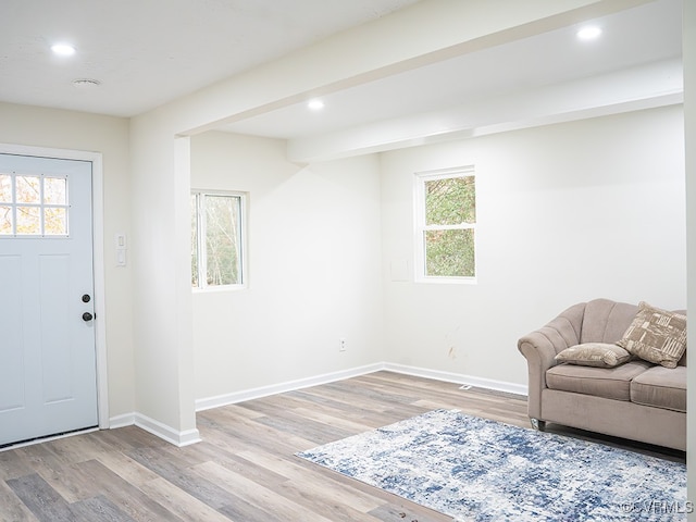 entryway with plenty of natural light, beamed ceiling, and light wood-type flooring