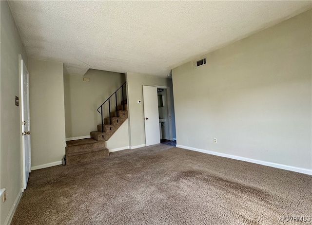 empty room with carpet and a textured ceiling