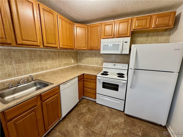 kitchen featuring a textured ceiling, white appliances, backsplash, and sink