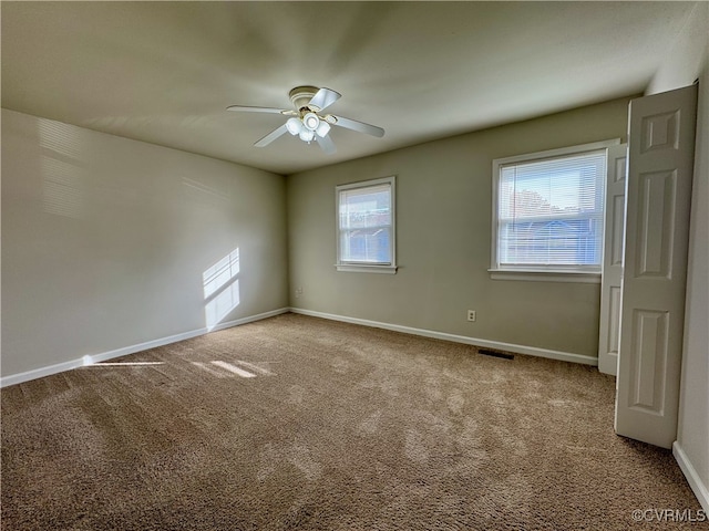 empty room featuring ceiling fan and carpet