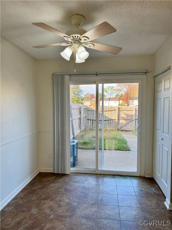 entryway with tile patterned floors, ceiling fan, and a textured ceiling