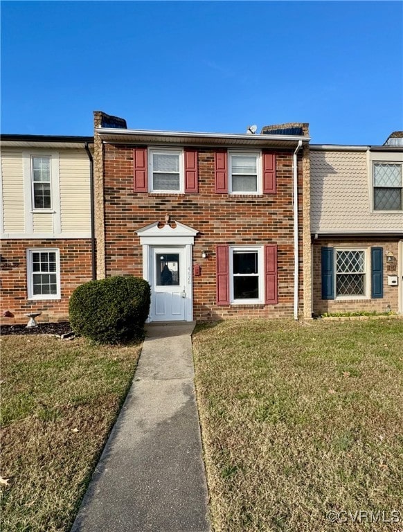 townhome / multi-family property with a front yard