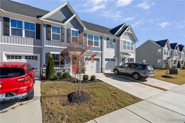 townhome / multi-family property with a garage and a front lawn