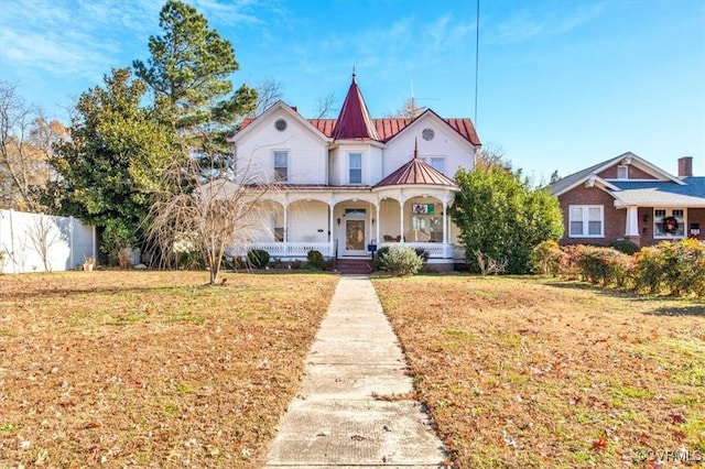 victorian house featuring a front yard and a porch