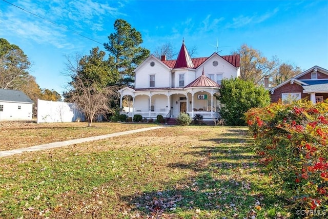 victorian-style house featuring a porch and a front yard