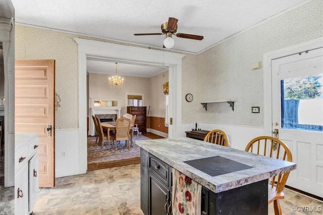 kitchen with crown molding and ceiling fan with notable chandelier