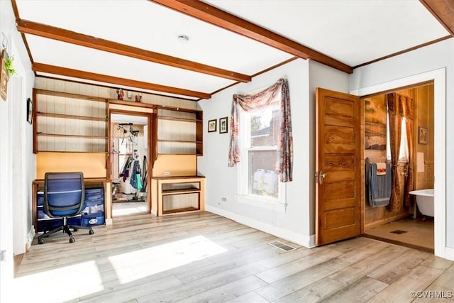 unfurnished office with beamed ceiling, crown molding, and light wood-type flooring