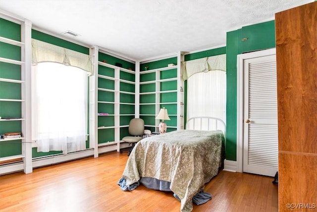 bedroom with hardwood / wood-style flooring and a textured ceiling