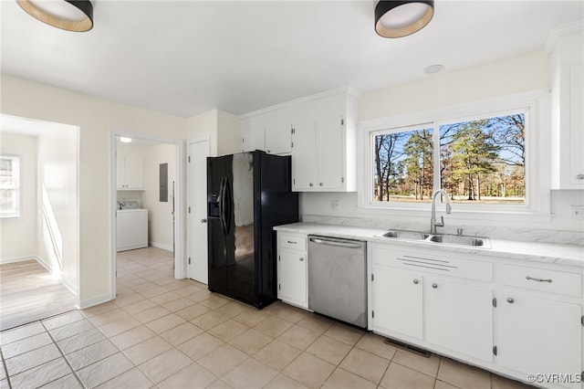 kitchen featuring sink, black fridge, stainless steel dishwasher, washer / clothes dryer, and white cabinets