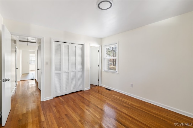 unfurnished bedroom featuring hardwood / wood-style floors and a closet