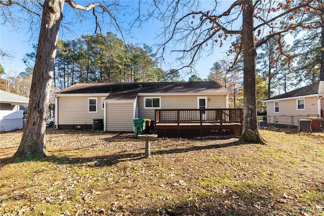 rear view of house featuring a yard, central air condition unit, and a wooden deck