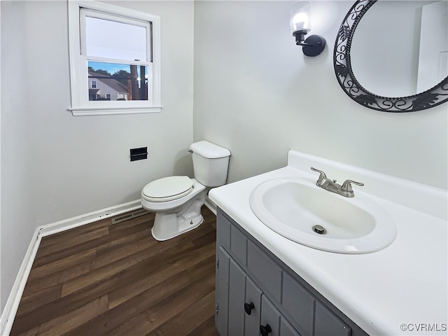 bathroom with hardwood / wood-style floors, vanity, and toilet